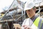 An architect on a building site using D.R. Horton's construction scheduling software