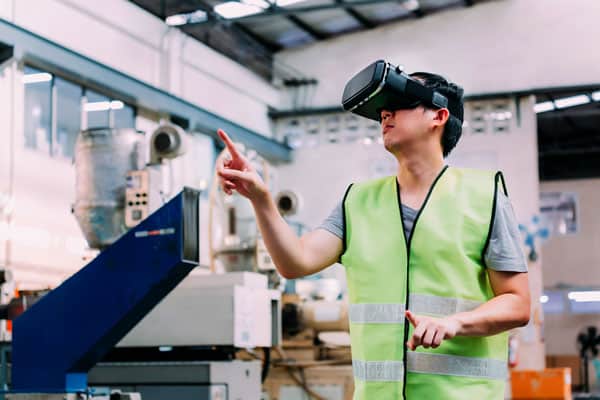 Man in yellow work vest using a virtual reality headset