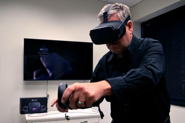 A man using a VR headset with a tv in the background