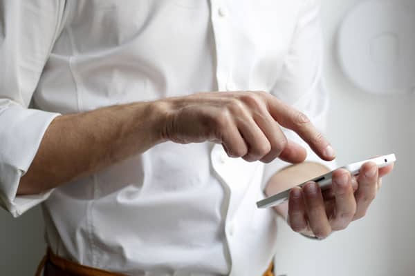 Man in white shirt using smartphone