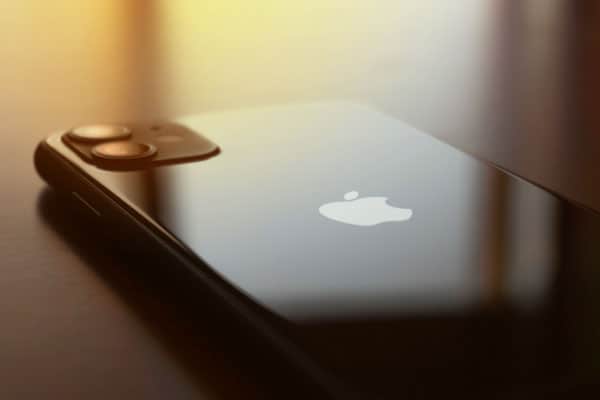 A black iphone laying screen down on a black table